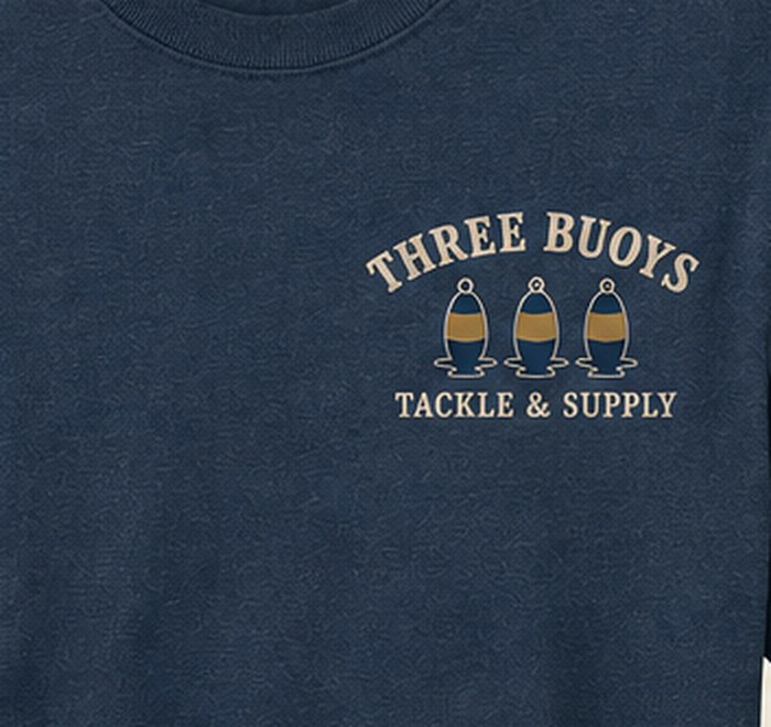 Close-up of the Three Buoys left-chest logo print on a navy tee